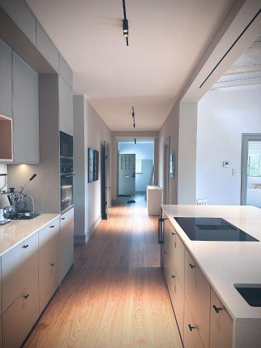 a kitchen with white cabinets and a wooden floor at The Embassy in Lund