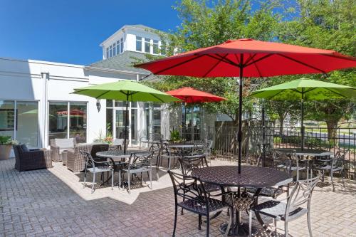 an outdoor patio with tables and chairs with umbrellas at Hilton Garden Inn Chesterton in Chesterton