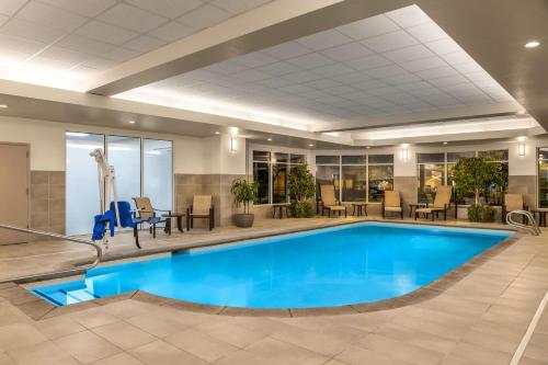 a pool in a hotel lobby with chairs and tables at Hilton Garden Inn Spokane Airport in Airway Heights