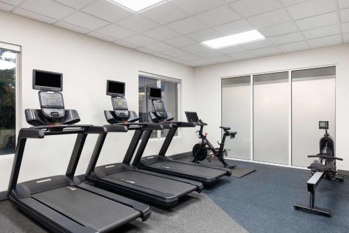 a gym with three treadmills and exercise bikes at Hilton Garden Inn Spokane Airport in Airway Heights
