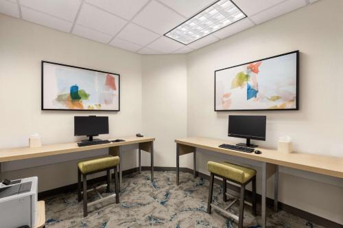 a waiting room with two desks and two monitors at Hilton Garden Inn Spokane Airport in Airway Heights