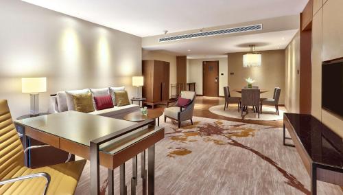 a living room with a couch and a dining room at Hilton Kota Kinabalu in Kota Kinabalu