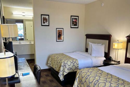 a hotel room with two beds and a mirror at Baymont by Wyndham Johnson City in Johnson City