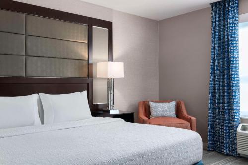 a hotel room with a bed and a chair at Hampton Inn & Suites-Worcester, MA in Worcester