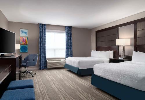 a hotel room with two beds and a television at Hampton Inn & Suites-Worcester, MA in Worcester