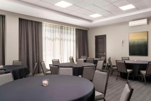 a conference room with tables and chairs and a screen at Hampton Inn & Suites-Worcester, MA in Worcester