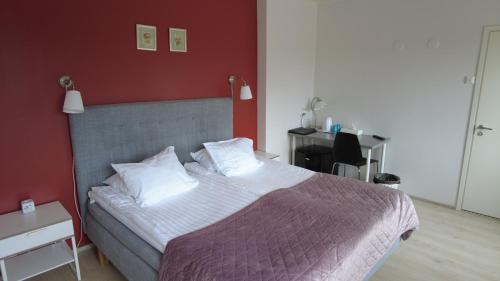 a bedroom with a large bed with a red wall at Lapin Satu in Posio