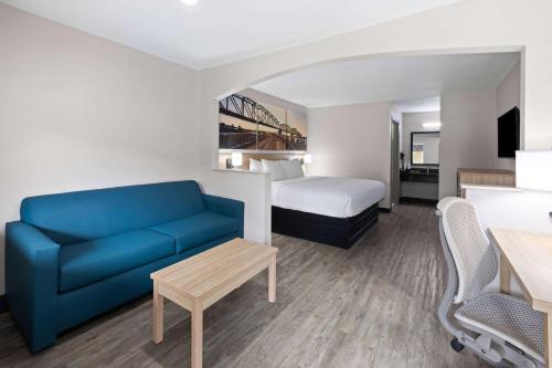 a hotel room with a couch and a bed at Days Inn by Wyndham North Little Rock Maumelle in Maumelle