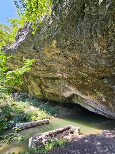 a pool of water in front of a rock formation at Art Racha in Ambrolauri