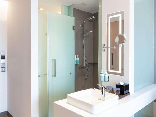 a bathroom with a sink and a shower at Novotel Phnom Penh BKK 1 in Phnom Penh