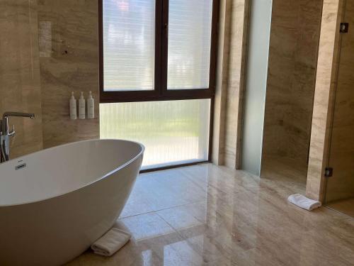 a bathroom with a white tub and a window at Swissotel Uludag Bursa in Bursa