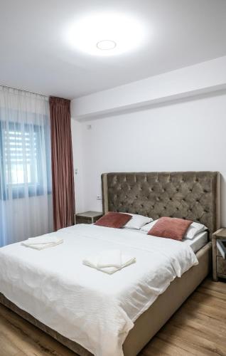 a bedroom with a large bed with white sheets at Zian Apartament in Craiova