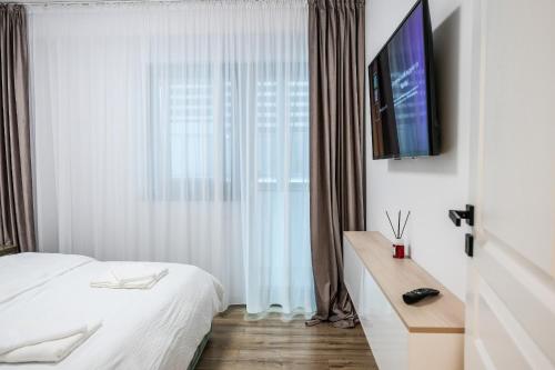 a bedroom with a bed and a television on a wall at Zian Apartament in Craiova