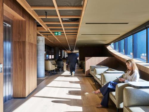 a woman sitting in a waiting room in a building at Novotel Melbourne Airport in Melbourne
