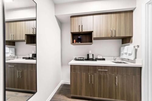 a kitchen with wooden cabinets and a sink at Quality Inn & Suites Port Lavaca near Lighthouse Beach in Port Lavaca