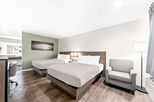 a bedroom with two beds and a desk and a chair at Quality Inn & Suites Port Lavaca near Lighthouse Beach in Port Lavaca