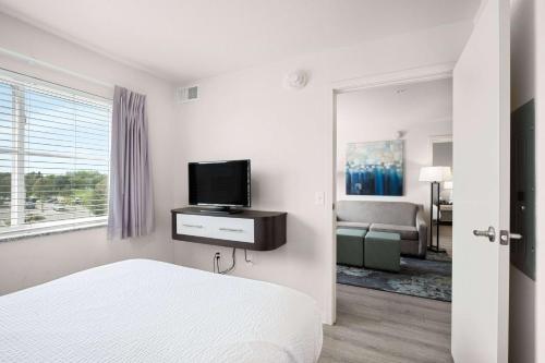 a bedroom with a bed and a tv on a wall at WaterWalk Extended Stay by Wyndham Minneapolis - Plymouth in Plymouth