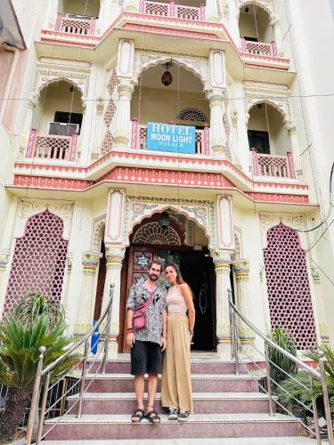 a man and woman standing in front of a building at Hotel Moon Light Palace in Jaipur