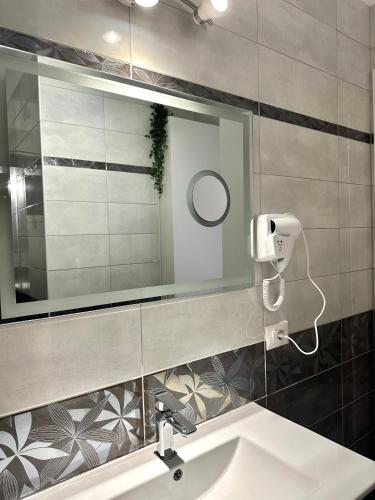 a bathroom with a sink and a mirror at Glenis Apartment Vollga in Durrës