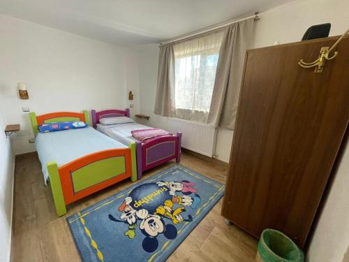 a small bedroom with a bed and a rug at MOGA House in Tîrnăveni