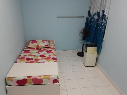 Habitación pequeña con cama y cubo de basura en Ns Guest House Puchong, en Puchong