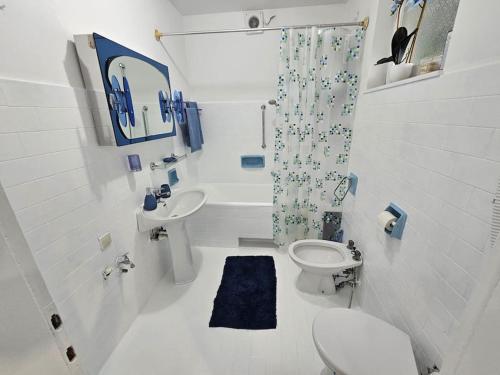 a white bathroom with a toilet and a sink at Violeta guest house in Petrovaradin