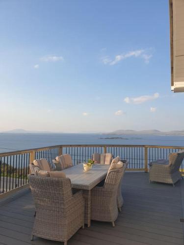 a wooden deck with a table and chairs on a balcony at Tom Jacks, coastal views and beach walks Connemara in Galway