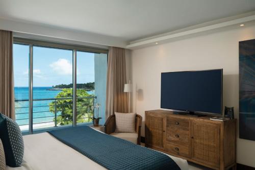 a hotel room with a bed and a flat screen tv at The Ocean Club, a Luxury Collection Resort, Costa Norte in Sosúa