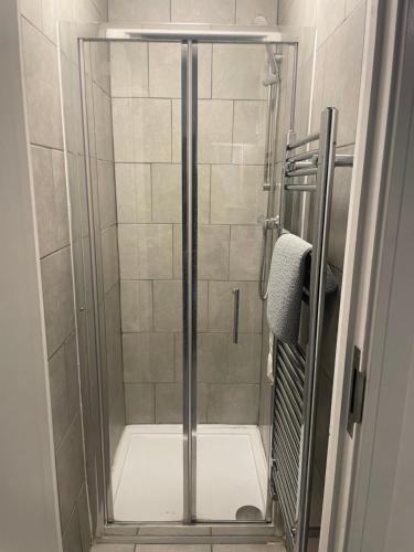 una ducha con puerta de cristal en un baño en Amazing studios 2 - East London, en Londres