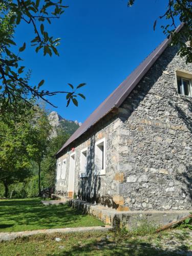 an old stone building with a red roof at Guest House Emanueli in Tropojë