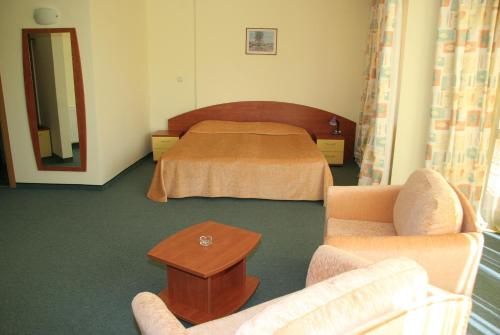 a hotel room with a bed and a table at Hotel Grand in Samokov