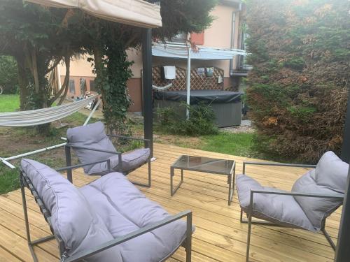 a patio with chairs and a hammock on a deck at Logement Sorbier Wattwiller in Wattwiller