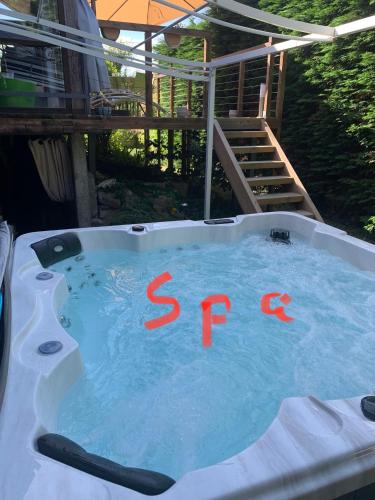 a hot tub with a sign in the water at Logement Sorbier Wattwiller in Wattwiller