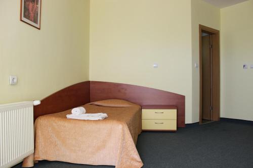 a small bedroom with a bed and a wooden headboard at Hotel Grand in Samokov