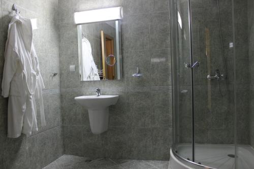 a bathroom with a shower and a sink and a shower at Hotel Grand in Samokov