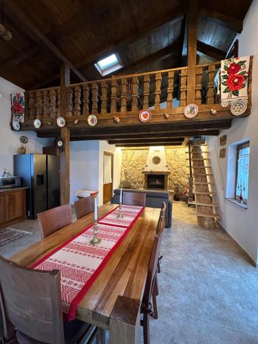 a dining room with a wooden table and a fireplace at La Casetta - O întreagă căsuță ca în povești in Baia-Sprie