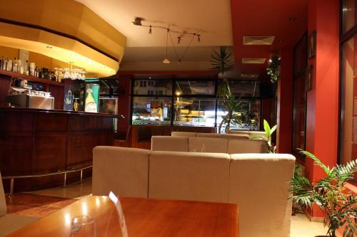 a restaurant with couches and a bar in the background at Hotel Grand in Samokov