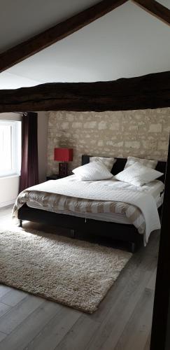 - une chambre avec un grand lit et une grande tête de lit en bois dans l'établissement Gite a la campagne, à Bougneau