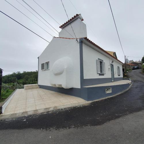 a white building with a large animal on the side at Casa do Forno in Lajes das Flores