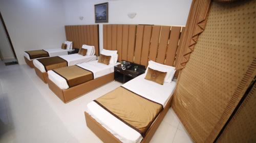 a group of beds in a room at Four Squares by WI Hotel in Karachi