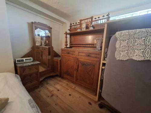 LevensにあるHappy Home Levensのベッドルーム1室(ベッド1台付)、木製ドレッサーが備わります。