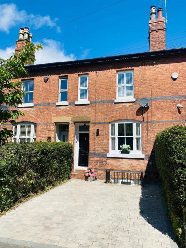 a brick house with a large driveway at Award Winning Elegant luxurious refurbished meticulous 3 Bed in Alderley Edge