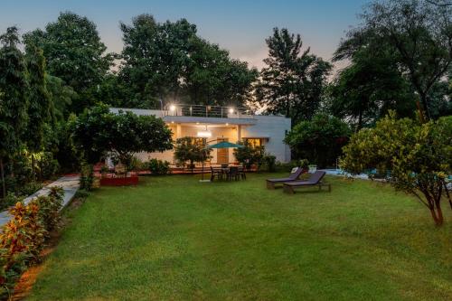 a white house with a yard with a lawn sidx sidx sidx at Alaya Stays 3 BHK Pet friendly with Pvt Pool - Daffodil in New Delhi
