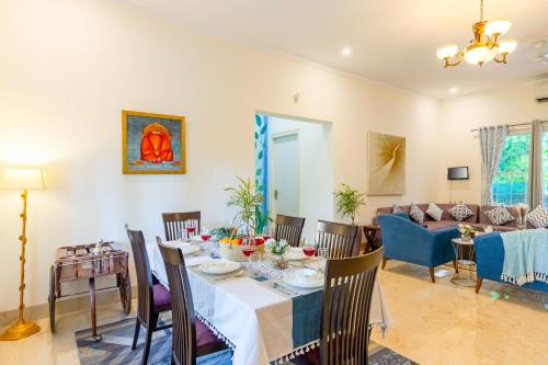 a dining room and living room with a table and chairs at Alaya Stays 3 BHK Pet friendly with Pvt Pool - Daffodil in New Delhi