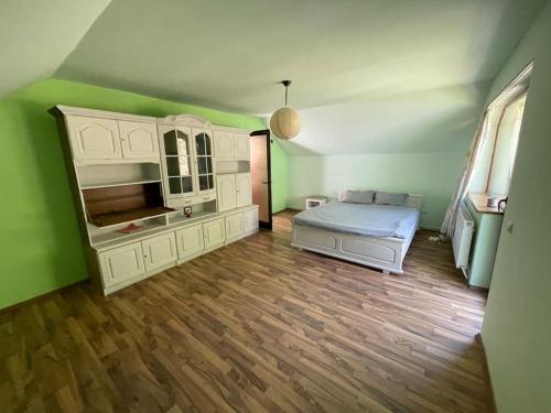 a green room with a bed and a mirror at Cabana Micesti in Miceşti