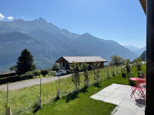 a view of a house with a table and vines at Appartement 2,5 pièces neuf avec terrasse in Vérossaz