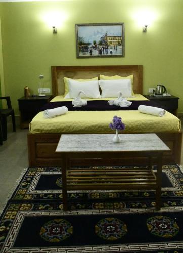a bedroom with a bed and a table with flowers on it at Mantra Inn Lachung in Lachung