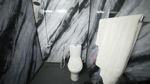 a bathroom with a white toilet and a towel at Four Squares by WI Hotel in Karachi