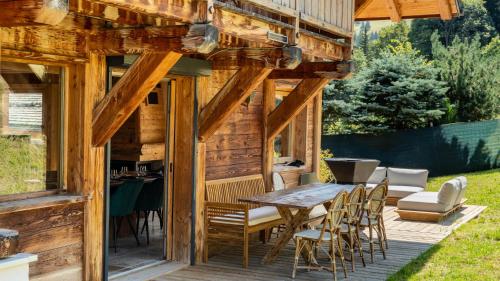 une cabine en bois avec une table et des chaises sur une terrasse dans l'établissement Chalet Vallée de Chamonix Randonnées, Rafting et Spa, à Saint-Gervais-les-Bains