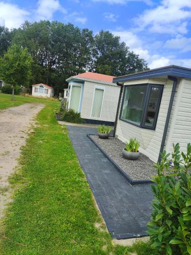 a house with a walkway next to a building at Chalet midden in de natuur! in Anloo